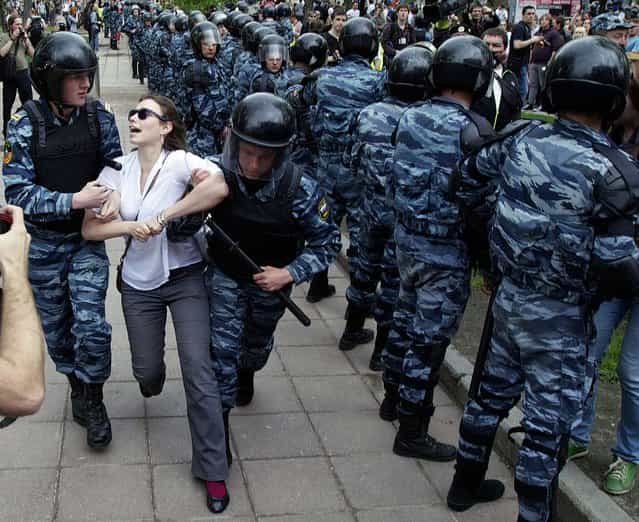 Police detain a woman after they broke up protesters gathering in downtown Moscow shortly before Vladimir Putin's inauguration on May 7, 2012