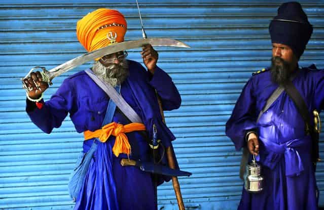 Indian Sikh Nihang holds his sword against his head to pray near the Sheesh Ganj Gurudwara Sikh temple in New Delhi, India on June 1, 2012