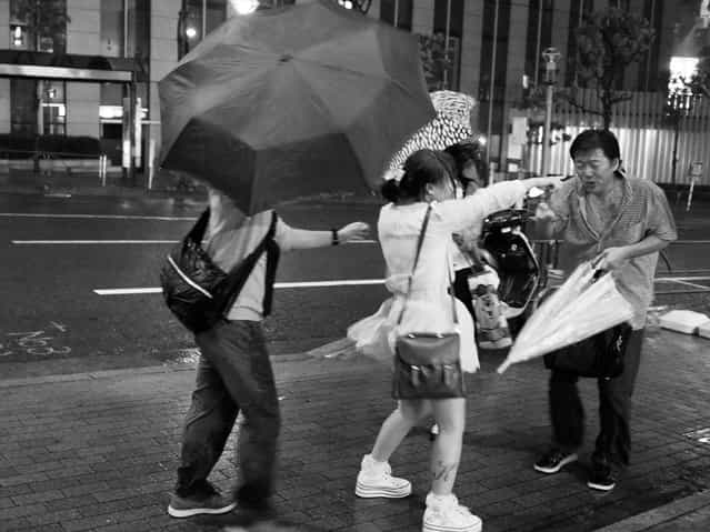 People walk against heavy rain and strong wind triggered by the Typhoon Guchol on June 19, 2012 in Meguro, Tokyo, Japan