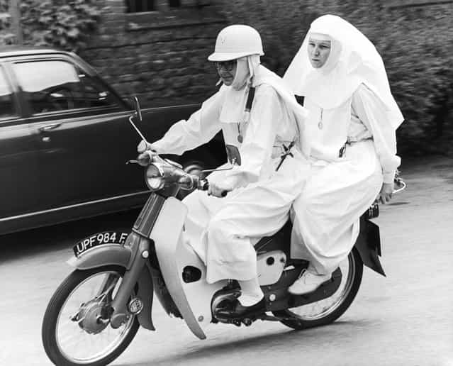 English nun Sister Joan Capistran taking Sister Mary Grace for a pillion ride on her 50cc Honda moped in the grounds of Ladywell Convent, Godalming, Surrey, 11th July 1969
