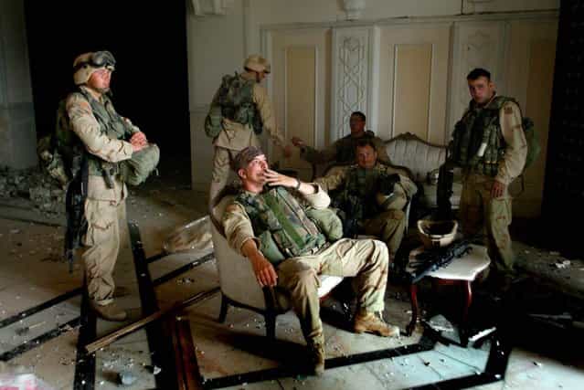 U.S. Army Stf. Sgt. Chad Touchett (center) relaxes with comrades from A Company, 3rd Battalion, 7th Infantry Regiment, following a search in one of Saddam Husseins palaces damaged after a bombing, in Baghdad