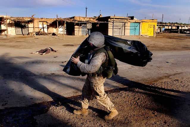A U.S. Marine carries the body of a fellow Marine killed in action after a coordinated ambush against American troops in Ramadi, April 6, 2004
