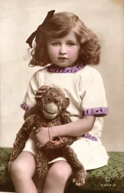1910: Joan Cooper, daughter of British actress Gladys Cooper, with a toy monkey