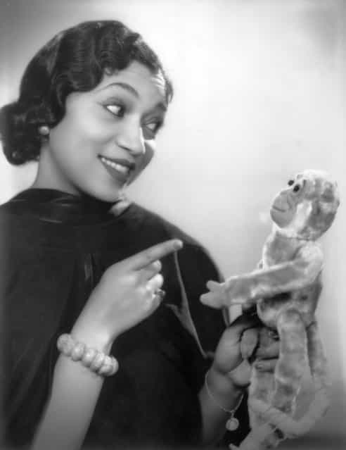 1933: British singer and actress Elizabeth Welch playfully admonishes a toy monkey
