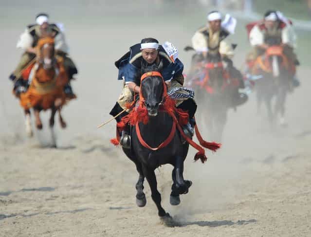 Local people in samurai costumes ride horses during the horse racing at the annual Soma Nomaoi festival in Minamisoma, Fukushima Prefecture, on July 28, 2012. The traditional full-scale festival kicked off for the first time after the accident of the Fukushima Dai-ichi Nuclear Power Plant following the massive earthquake and the tsunami on March 11, 2011. (Photo by Toru Yamanaka/AFP Photo)