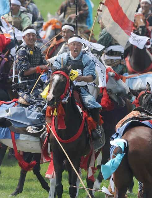 A local man in samurai armor riding his horse reacts after catching a yellow sacred flag at the annual Soma Nomaoi Festival in Minamisoma, Fukushima Prefecture, on July 29, 2012. Some 400 horses and thousands of people took part in the 1,000-year-old [Soma Nomaoi], or wild horse chase, at the weekend in the shadow of Japans crippled Fukushima nuclear plant. (Photo by Toru Yamanaka/AFP Photo)