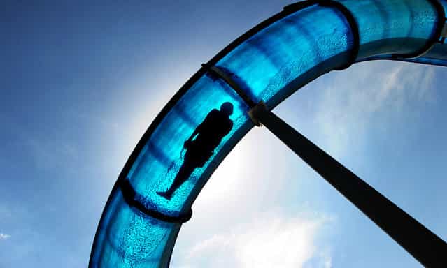 A boy slips down a waterslide in the German city of Hameln on May 22, 2012 as temperatures rose to up to 30 degrees Celsius (86F). (Photo by Julian Stratenschulte/AFP)