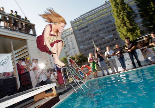 A participant of the the [Dirndlspringen] contest jumps into a swimming pool in Vienna, on June 16, 2012. At Dirndlspringen, a jury votes on the best performance of people jumping into a swimming pool in traditional Austrian Dirndl dresses. (Photo by Herwig Prammer/Reuters)