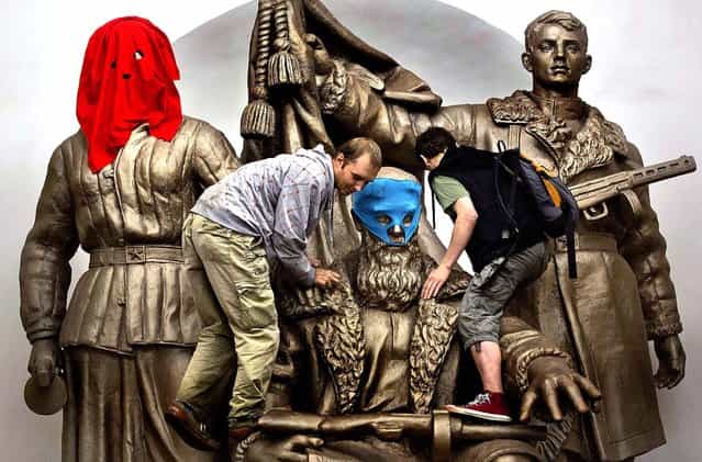 Pussy Riot supporters place masks on a monument to WWII heroes to resemble members of the group, at a subway station in Moscow. (Photo by Yevgeny Feldman/Novaya Gazeta)