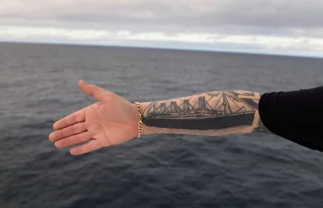 Derek Chambers from Belfast shows his tattoo of the Titanic, aboard the MS Balmoral Titanic memorial cruise ship in the Atlantic Ocean, on April 12, 2012. Nearly 100 years after the Titanic went down, the cruise with the same number of passengers aboard set sail to retrace the ship's voyage, including a visit to the location where it sank. (Photo by Lefteris Pitarakis/AP Photo)