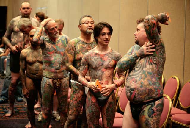 Jeff Bitting (right), from St Augustine, Florida, speaks backstage with fellow full-body tattoo contestants before judging at the National Tattoo Association Convention in Cincinnati, Ohio, on April 13, 2012. In his 33 years of getting tattoos, Bitting says he has had about 500 hours of work and will complete his other leg in his bid to win more full-body contests. (Photo by Larry Downing/Reuters)