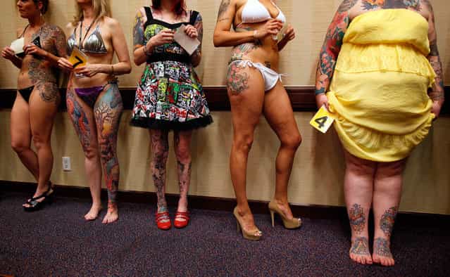 Keisha Holcomb (right), 31, from Fort Collins, Colorado, waits in line to have her tattoos judged in a contest during the National Tattoo Association Convention in Cincinnati, Ohio, on April 13, 2012. Holcomb, the product of a military family upbringing, was 16 when she got her first tattoo and is now a budding tattoo artist herself. She wants to have a full-body tattoo eventually, with the exception of her hands, throat and head. [Try to keep it classy], she says. (Photo by Larry Downing/Reuters)