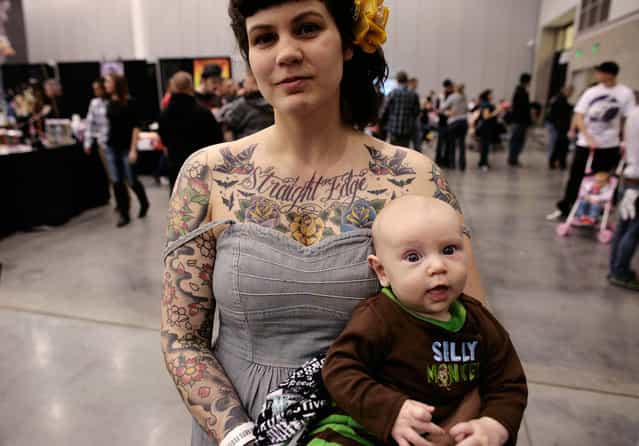 A tattooed participant in the Hampton Roads Tattoo Festival holds her baby in Virginia, on March 3, 2012. (Photo by Larry Downing/Reuters)