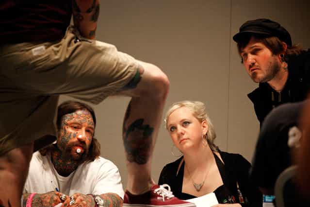 Tattoo judges inspect the tattoos of a competitor at the Hampton Roads Tattoo Festival in Virginia, on March 2, 2012. (Photo by Larry Downing/Reuters)