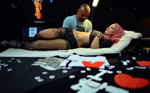 A visitor to the 17th International Tattoo and Piercing Convention in the Westfalenhallen in Dortmund, Germany, is tattooed on June 15, 2012. (Photo by Sascha Schuermann/AP Photo)
