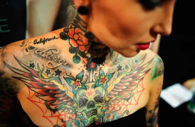 A visitor to a Tattoo and Piercing Convention event shows her tattoos in Dortmund, Germany, on June 15, 2012. (Photo by Sascha Schuermann/AP Photo)