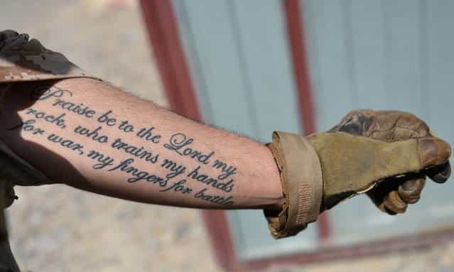 A US Marine from Kilo Company of the 3rd Battalion 8th Marines Regiment shows his tattoo during a patrol in Garmser, Helmand Province, Afghanistan, on June 27, 2012. (Photo by Adek Berry/AFP)