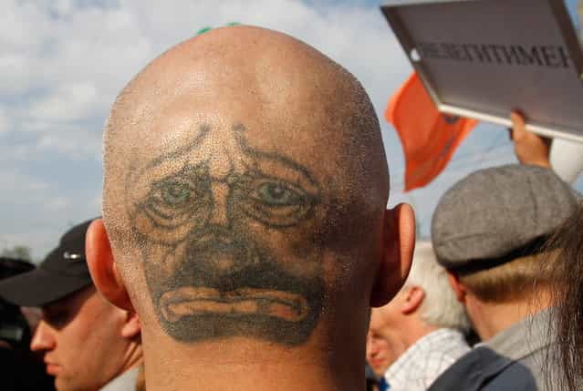 A protester with a face tattooed on the back of his head takes part in the [march of the million] opposition protest in central Moscow, on May 6, 2012. Russian riot police beat protesters with batons and hauled away dozens on Sunday after skirmishes broke out at a demonstration in Moscow against Vladimir Putin on the eve of his return to the presidency. (Photo by Denis Sinyakov/Reuters)