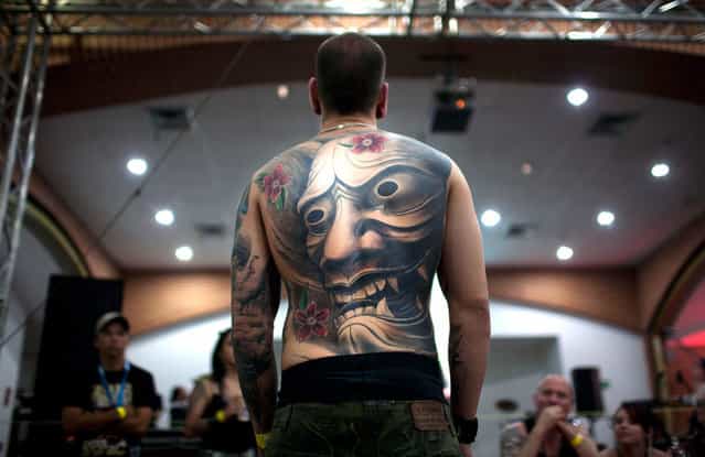 A man shows his tattoos as he attends the Venezuela Expo Tattoo in Caracas, Venezuela, on January 28, 2012. (Photo by Ariana Cubillos/AP Photo)