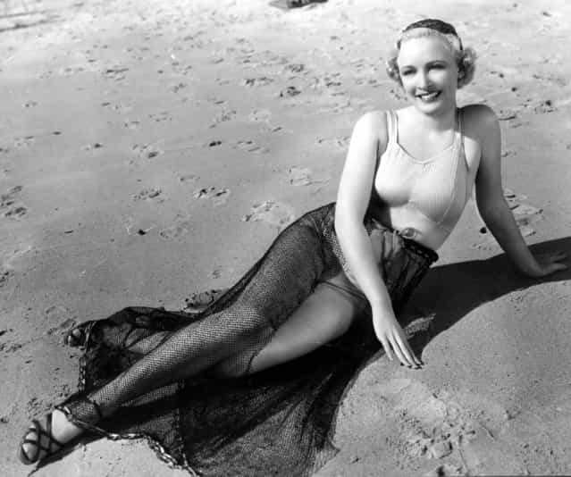 Wearing a satin and lastex top and a skirt made of fishnet Ann Evors, a Paramount player, poses for the cameramen on the beach, circa 1928. (Photo by Central Press)