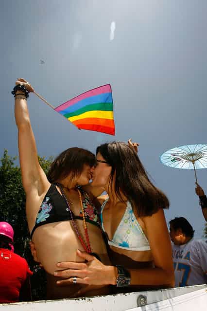 Helanie Nicolas (L) and Emmanuelle Urex, both from France, kiss as they ride for their first time in the 38th annual LA Pride Parade June 8, 2008 in West Hollywood, California. (Photo by David McNew)