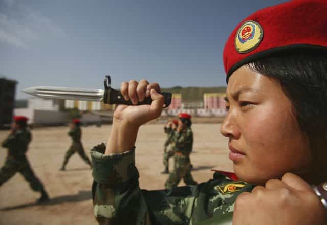 XINING, CHINA - AUGUST 8: (CHINA OUT) A member of a female grappling team from Qinghai Province armed police undergoes dagger exercise on August 8, 2006 in Xining of Qinghai Province, China. The female grappling team, established in May 2006, has 40 women soldiers aged 18 to 21. The training program includes grappling, boxing, dagger exercise and shooting. (Photo by China Photos/Getty Images)
