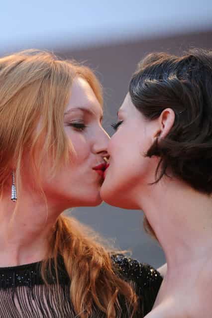 French actress Roxane Mesquida (R) and Josephine De La Baume exchange a kiss on the red carpet prior the screening of The company you keep during the 69th Venice Film Festival on September 6, 2012 at Venice Lido. The company you keep is presented out of competition. AFP PHOTO / TIZIANA FABI