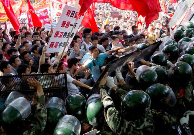 Chinese demonstrators clash with policemen at barricades during an anti-Japanese protests outside the Japanese Embassy in Beijing, on Saturday, September 15, 2012. (Photo by Andy Wong/AP Photo)