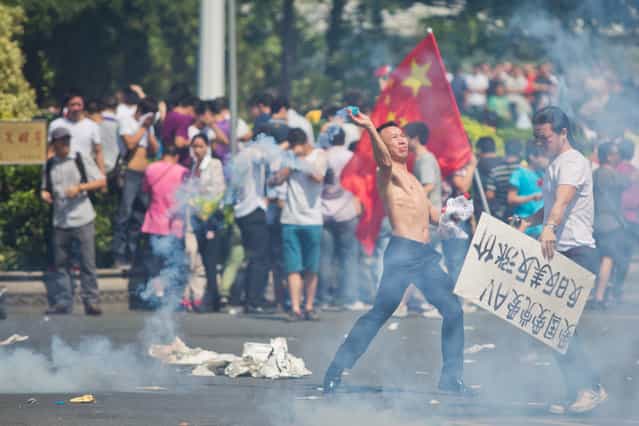 An anti-Japanese protester throws a gas canister during a demonstration on September 16, 2012 in Shenzhen, China. Protests have taken place across China in the dispute that is becoming increasingly worrying for regional stability. (Photo by Lam Yik Fei)