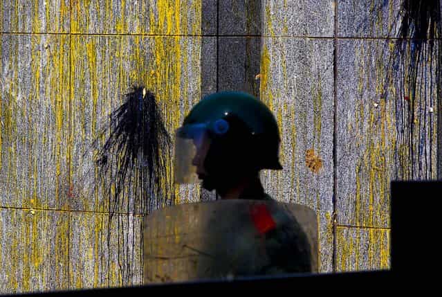 A paramilitary policeman guards an entrance of the Japanese Embassy with eggs and paint splattered on its wall, in Beijing, China, September 16, 2012 during demonstrations over islands that both nations claim are theirs. (Photo by Alexander F. Yuan/Associated Press)