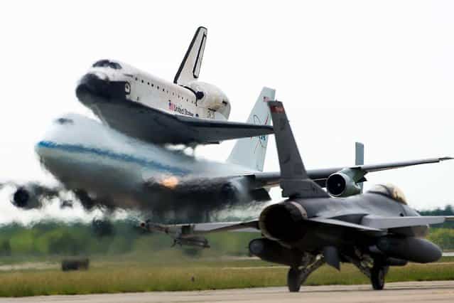 The space shuttle Endeavour, carried atop NASA's 747 Shuttle Carrier Aircraft, lands at Houston's Ellington Field past an aircraft from the Texas Air National Guard 147th Reconnaissance Wing on September 19, 2012. (Photo by Smiley N. Pool/Houston Chronicle)