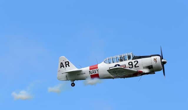 A pilot performs aerobatics in a vintage Harvard aircraft during an airshow commemorating the completion of the the rebuild of Havilland Mosquito KA 114, on September 29, 2012 in Ardmore, New Zealand. The plane was restored by Warbird Restorations at Ardmore Aerodrome and is the only flying Mosquito in the world. (Photo by Simon Watts)
