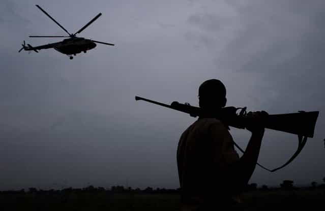 A forest official stands guard on October 1, as an Indian Air force helicopter flies to search for a rhinoceros that strayed from the Pobitora wildlife sanctuary in Rani Chapori, an island in the Brahmaputra River in Suwalkuchi in Assam state. Officials are urgently serching for the rhino: a least four rhinos have been killed recently by poachers, sparking outrage in the state, home to the world's largest concentration of the rhinos. (Anupam Nath/Associated Press)
