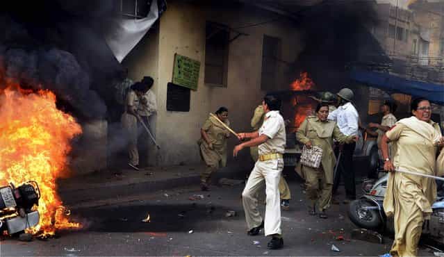 Police personnel run after their police station in Ahmadabad, India, was attacked by a mob during a protest against the anti-Islam film [Innocence of Muslims], on October 3, 2012. (Photo by Associated Press)