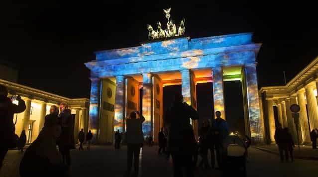 The Brandenburg Gate is illuminated during the rehearsal of the ninth Festival Of Lights in Berlin, on October 9, 2012. (Photo by Markus Schreiber/Associated Press)