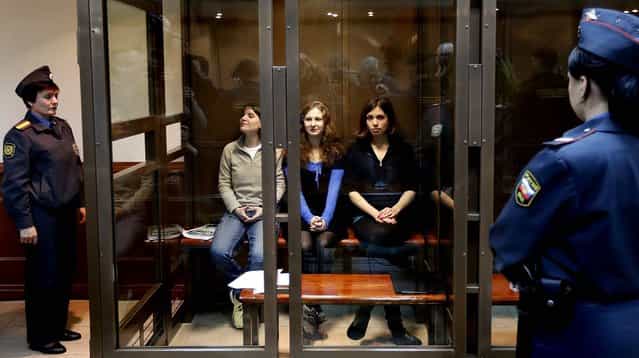 Feminist punk group Pussy Riot members Maria Alekhina, Yekaterina Samutsevich and Nadezhda Tolokonnikova sit in a glass cage in a courtroom in Moscow, on October 10, 2012. The women are set to make their case before a Russian appeals court that they should not be imprisoned for their irreverent protest against President Vladimir Putin. Their impromptu performance inside Moscow's main cathedral in February came shortly before Putin was elected to a third term. The women were convicted in August of hooliganism motivated by religious hatred and sentenced to two years in prison. (Photo by Sergey Ponomarev/Associated Press)