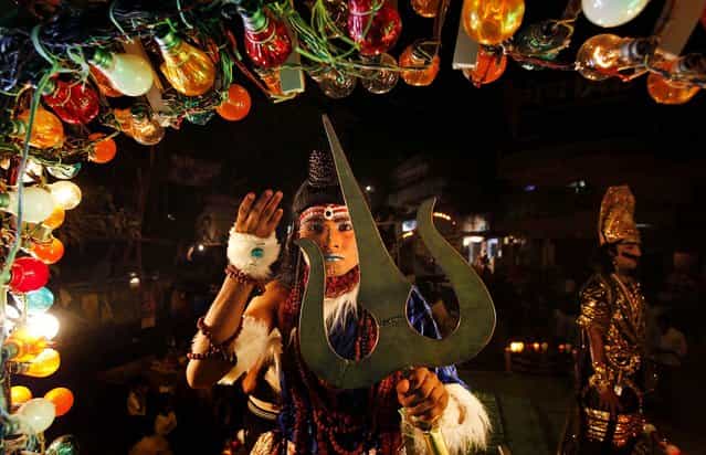 An artist dressed as a Hindu God participates in a Dussehra procession in the northern Indian city of Allahabad, on October 11, 2012. The procession was part of Hindu festival Dussehra celebrations, commemorating the triumph of Lord Rama over the demon king Ravana, marking the victory of good over evil. (Photo by Rajesh Kumar Singh/Associated Press)