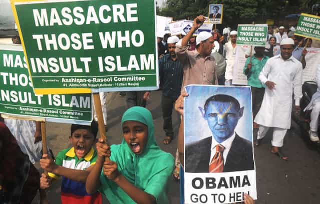 Indian Muslim children hold anti-US placards as they participate in a protest meeting against the film [Innocence of Muslims] in Kolkata on October 5, 2012. A low-budget, US-produced [Innocence of Muslims] movie has incited a wave of bloody anti-US violence in Libya, Egypt, Sudan, Tunisia, Yemen and in several other countries across the Muslim world. (Photo by Dibyangshu Sarkar/AFP/AFP Photo)