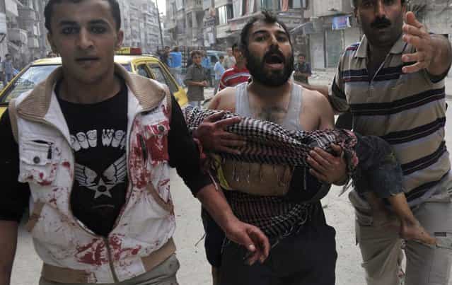 A Syrian man carries the body of his five-year-old son Mohammed Mustafa outside a hospital following shelling by Syrian government forces during battle with rebel fighters in the northern city of Aleppo on October 10, 2012. Syrian rebels took control of Maaret al-Numan, a strategic Idlib province town on the highway linking Damascus with second city Aleppo, said the Syrian Observatory for Human Rights. (Photo by Tsauseef Mustafa)