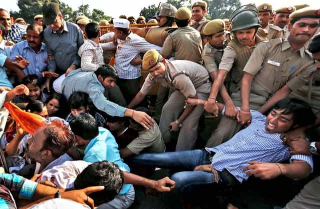 India Against Corruption activists are carried away by police as they sit with disabled people to protest against alleged embezzlement of government funds meant for the welfare of the disabled, in New Delhi, India, on October 12, 2012. (Photo by Saurabh Das/Associated Press)