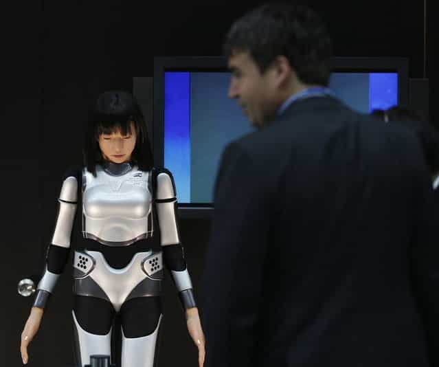 A man is [welcomed] Tuesday by a HRP-4C Miim humanoid robot at Tokyo International Forum which is hosting the annual meetings of the International Monetary Fund and the World Bank Group on October 10, 2012. (Photo by Reuters)