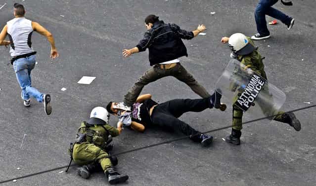 Riot police fight with demonstrators during clashes in front of the parliament in Athens, on October 9, 2012. Paying her first visit to Greece in five years, German chancellor Angela Merkel's arrival triggered protests by some 50,000 demonstrators. (Photo by Dimitri Messinis/Associated Press)