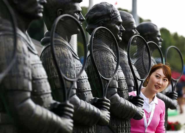 A woman looks at a statue of Roger Federer at Qizhong Forest Sports City Tennis Center where the Shanghai, on October 8, 2012. Masters tennis tournament is taking 

<div class=