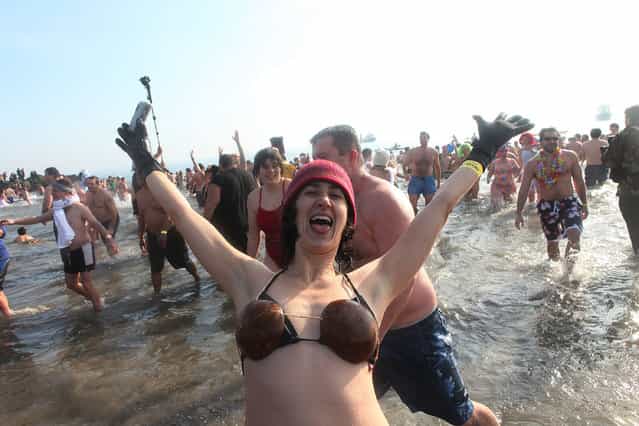 A woman celebrates after participating in the annual Coney Island Polar Bear Club New Year's Day swim at Coney Island on January 1, 2011 in the Brooklyn borough of New York City. The Coney Island Polar Bear Club claims itself as the oldest winter bathing organization in the U.S. and attracts hundreds to the beach for the annual swim in the Atlantic Ocean. (Photo by Andrew Burton)
