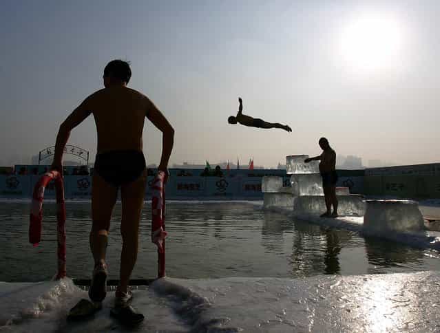 A winter swimming performer dives into a pool carved out of the frozen Songhua river during the 22nd Harbin International Ice and Snow Festival on January 11, 2006 in Harbin, Heilongjiang Province in north China. Harbin is one of China's coldest cities and each winter hosts an ice festival, with famous buildings and landmarks from around the world recreated in ice. (Photo by Cancan Chu)