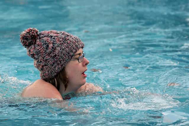 A swimmer wears a woollen hat during the Winter Swim at Brockwell Lido on December 19, 2009 in London, England. Ice had to be broken from the surface of the open air pool for the annual winter swim where swimmers of all ages brave the cold water for the honour of becoming a Brockwell Icicle and to raise money for charity. (Photo by Dan Kitwood)