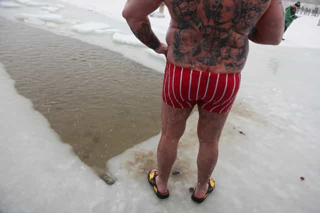 A tatooed participant relaxes after taking a quick dip in frozen Orankesee lake at the 26th annual Berlin Seals winter swim on January 9, 2010 in Berlin, Germany. Approximately a dozen ice swimming clubs joined the annual event as a chilly snowstorm swept across Germany. (Photo by Sean Gallup)