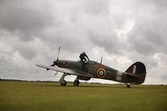 A Hawker Hurricane Mk XIIa 5711 (G-HURI) fighter aircraft returns from performing an aerobatic display at the IWM Duxford on October 18, 2012 in Duxford, England. The aeroplane, similar to those that defended British shores during the Battle of Britain in World War II, is due to be auctioned by Bonhams in their sale of [Collectors' Motor Cars and Automobilia] at Mercedes-Benz World Brooklands on December 3, 2012. The plane was built in 1942 and joined the Royal Canadian Air Force the following year, where it remained for the duration of the war, it is expected to fetch up to 17 million GBP. (Photo by Oli Scarff)