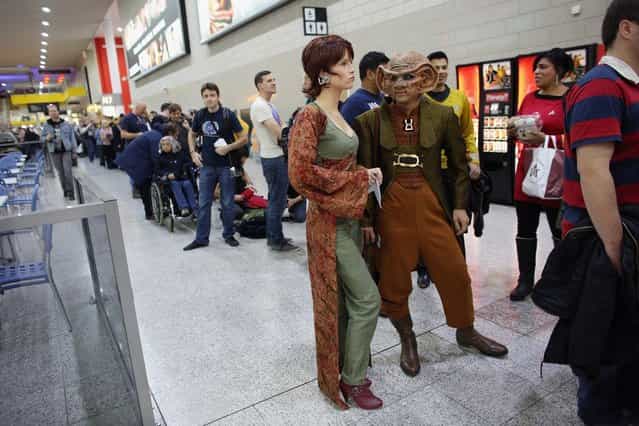 A woman dressed as the Star Trek character 'Leeta' (C) and man dressed as 'Rom' (2R) arrive to attend the [Destination Star Trek London] convention at the ExCeL centre on October 19, 2012 in London, England. The three-day convention, which opened to the general public today, will be attended by all five actors who played captains throughout the 46-year-old series. (Photo by Oli Scarff)
