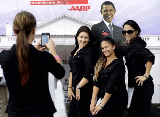 Workers later pose for a photo with the cutout of President Obama. (Photo by Eric Gay/Associated Press)